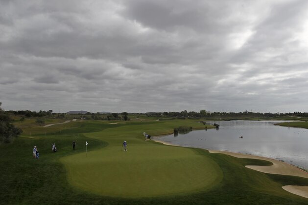Scotland's Scott Jamieson, third left, chips the ball onto the 11th hole during the third round of the Portugal Master golf tournament at the Victoria golf course in Vilamoura, southern Portugal, Saturday, Oct. 12, 2013. (AP Photo/Francisco Seco)