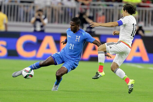 Honduras' Brayan Beckeles (21) keeps the ball away from Mexico's Andres Guarded (18) during the first half of a soccer match Wednesday, July 1, 2015 in Houston. (AP Photo/Bob Levey)