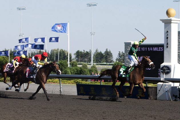 Jockey Eurico Rosa da Silva celebrates his win while riding horse Big Red Mike at the 151st running of The Queen's Plate at Woodbine Racetrack in Toronto on Sunday, July 4, 2010. The royal couple is on a nine-day tour of Canada. THE CANADIAN PRESS/Nathan Denette
