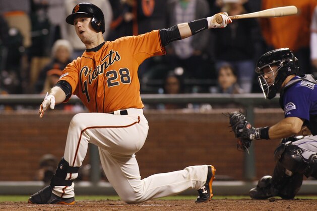 San Francisco Giants' Buster Posey swings and misses during the ninth inning of a baseball game against the Colorado Rockies, Friday, June 26, 2015, in San Francisco. Rockies catcher Nick Hundley is at right. (AP Photo/George Nikitin)