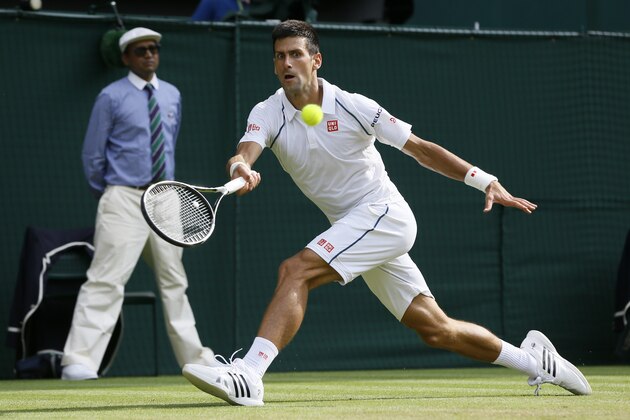 Novak Djokovic of Serbia returns a ball to  Bernard Tomic of Australia during their singles match at the All England Lawn Tennis Championships in Wimbledon, London, Friday July 3, 2015. (AP Photo/Kirsty Wigglesworth)