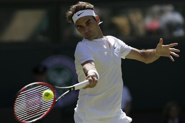 Roger Federer of Switzerland returns a ball to Damir Dzumhur of Bosnia during the singles first round match at the All England Lawn Tennis Championships in Wimbledon, London, Tuesday June 30, 2015. (AP Photo/Tim Ireland)