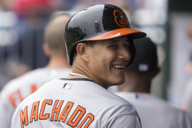 Baltimore Orioles' Manny Machado looks back with a smile while in the dugout during the fifth inning of a baseball game against the Philadelphia Phillies, Thursday, June 18, 2015, in Philadelphia. (AP Photo/Chris Szagola)