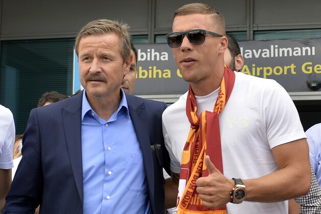 Lukas Podolski, of Germany, right, poses for pictures with Galatasaray manager left, after he arrived at the airport in Istanbul, Saturday, July 4, 2015. The German international arrived to sign a contract with the Turkish club. (AP Photo)