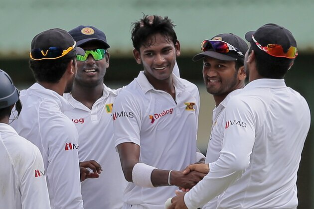 Sri Lanka's Dushmantha Chamera, center, celebrates his maiden test wicket with teammates during the first day of the second test cricket match against Pakistan in Colombo, Sri Lanka, Thursday, June 25, 2015. (AP Photo/Eranga Jayawardena)