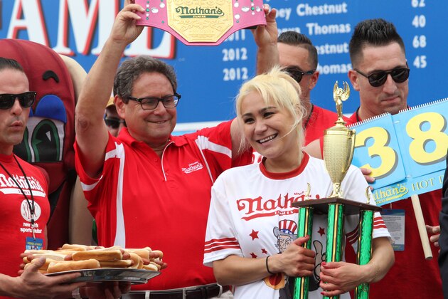 Miki Sudo, second from right, holds her trophy and smiles after winning the Nathan's Famous Fourth of July International Hot Dog Eating Contest women's competition Saturday, July 4, 2015, at Coney Island in the Brooklyn borough of New York. Sudo ate 38 hot dogs and buns in 10 minutes. (AP Photo/Tina Fineberg)(AP Photo/Tina Fineberg)