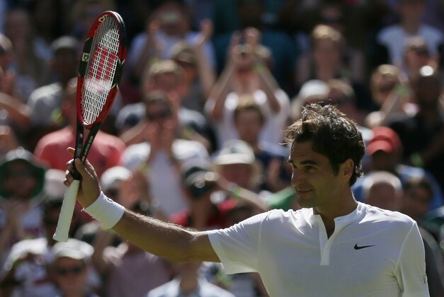 Roger Federer of Switzerland celebrates defeating Sam Groth of Australia in their singles match at the All England Lawn Tennis Championships in Wimbledon, London, Saturday July 4, 2015. Federer won the match 6-4, 6-4, 6-7, 6-2. (AP Photo/Tim Ireland)
