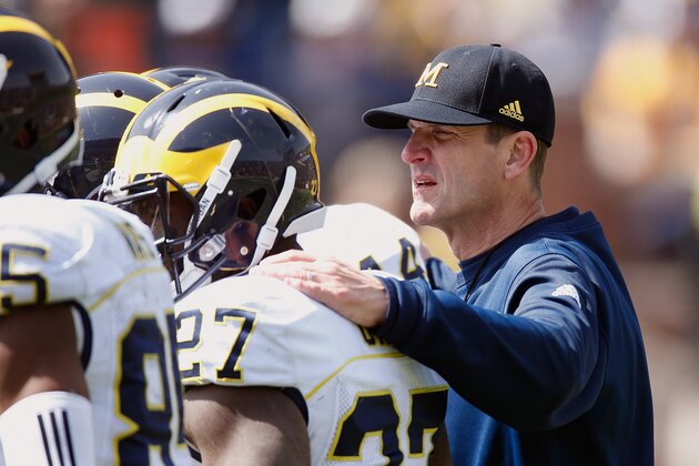ANN ARBOR, MI - APRIL 04: Head coach Jim Harbaugh of the Michigan Wolverines listens in on a offensive huddle during the Michigan Football Spring Game on April 4, 2015 at Michigan Stadium in Ann Arbor, Michigan.  (Photo by Gregory Shamus/Getty Images)