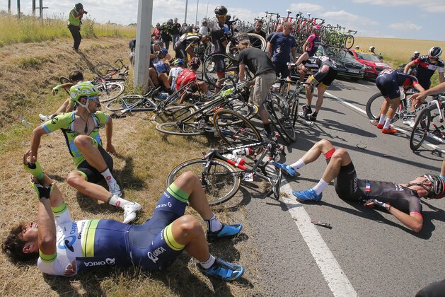Scores of riders lie on the road after crashing during the third stage of the Tour de France cycling race over 159.5 kilometers (99.1 miles) with start in Antwerp and finish in Huy, Belgium, Monday, July 6, 2015. (AP Photo/Christophe Ena)