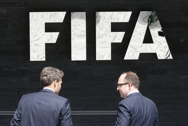 Two men talk to each other in front of the FIFA logo at the FIFA headquarters in Zurich, Switzerland, Wednesday, May 27, 2015. Swiss prosecutors opened criminal proceedings into FIFA's awarding of the 2018 and 2022 World Cups, only hours after seven soccer officials were arrested Wednesday pending extradition to the U.S. in a separate probe of Two men talk to each other in front of the FIFA logo at the FIFA headquarters in Zurich, Switzerland, Wednesday, May 27, 2015. Swiss prosecutors opened criminal proceedings into FIFA's awarding of the 2018 and 2022 World Cups, only hours after seven soccer officials were arrested Wednesday pending extradition to the U.S. in a separate probe of