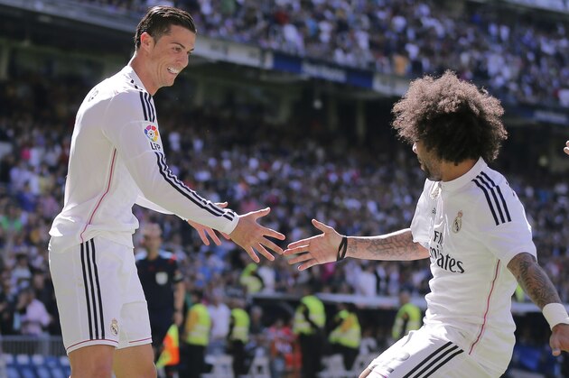 Real Madrid's Cristiano Ronaldo, left, celebrates with team mate Marcelo, center, and Real Madrid's Gareth Bale after scoring a goal during a La Liga soccer match between Real Madrid and Granada at the Santiago Bernabeu stadium in Madrid, Spain, Sunday, April 5, 2015. (AP Photo/Daniel Ochoa de Olza)