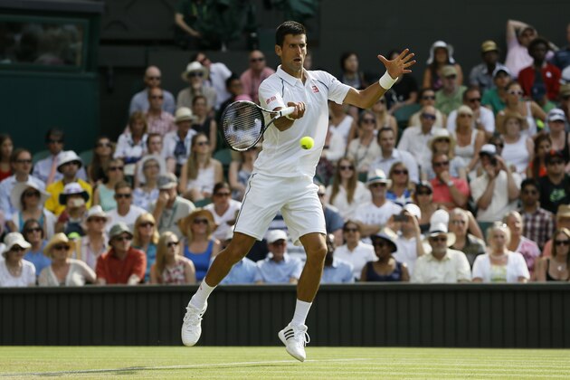 Novak Djokovic of Serbia returns a ball to  Bernard Tomic of Australia during their singles match at the All England Lawn Tennis Championships in Wimbledon, London, Friday July 3, 2015. (AP Photo/Kirsty Wigglesworth)