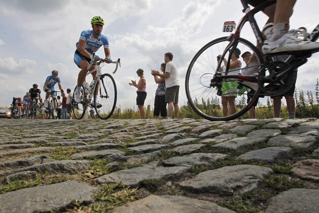In this Tuesday July 6, 2010 file photo riders pass a cobblestone section during the third stage of the Tour de France cycling race over 213 kilometers (132.4 miles) with start in Wanze, Belgium and finish in Arenberg, France. At 155.5 kilometers the fifth stage of the 2014 edition of the Tour de France is not particularly long. But it features nine patches of cobblestones, many of them familiar in the joint-jarring Paris-Roubaix one-day race. The key for the race's big guns will be to stay at the front of the pack to avoid crashes on a treacherous and dusty terrain usually tackled at a frenetic pace. Punctures are also frequent on cobblestones, and can end a rider's hopes of winning the race.  (AP Photo/Christophe Ena, File)