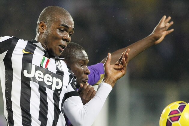 Fiorentina's Khouma Babacar  is challenged by Juventus' Angelo Ogbonna, foreground, during a Serie A soccer match at the Artemio Franchi stadium in Florence, Italy , Friday Dec. 5  2014. (AP Photo/Fabrizio Giovannozzi)