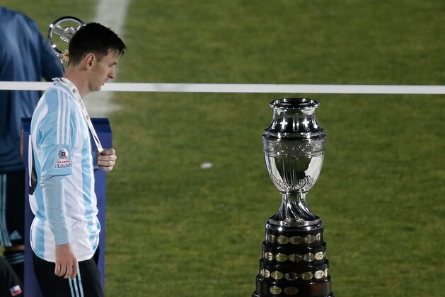 Argentina's Lionel Messi walks next to the Copa America trophy during the Copa America final soccer match at the National Stadium in Santiago, Chile, Saturday, July 4, 2015. (AP Photo/Silvia Izquierdo)