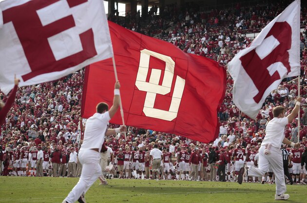 NORMAN, OK - NOVEMBER 16:  A member of the Oklahoma Sooners spirit squad waves a flag after a touchdown against the Iowa State Cyclones November 16, 2013 at Gaylord Family-Oklahoma Memorial Stadium in Norman, Oklahoma. Oklahoma defeated Iowa State 48-10. (Photo by Brett Deering/Getty Images)