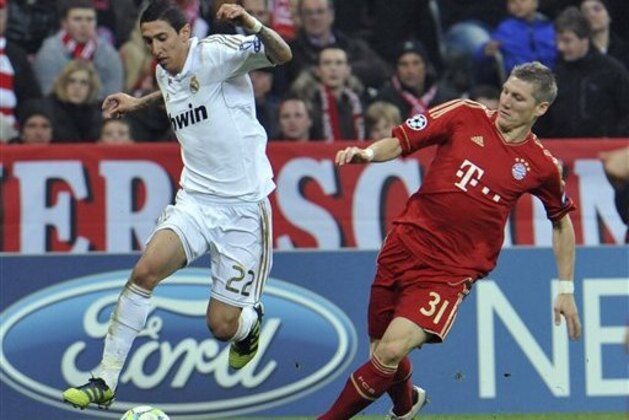 Madrdi's Angel Di Maria, left, is followed by Bayern's Bastian Schweinsteiger during the Champions League first leg semifinal soccer match between Bayern Munich and Real Madrid in Munich, southern Germany, Tuesday, April 17, 2012. (AP Photo/Kerstin Joensson)