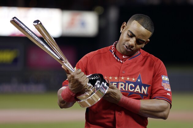 American League's Yoenis Cespedes, of the Oakland Athletics, holds the trophy after winning the MLB All-Star baseball Home Run Derby, Monday, July 14, 2014, in Minneapolis. Cespedes defeated National League's Todd Frazier, of the Cincinnati Reds, in the finals. (AP Photo/Jeff Roberson)