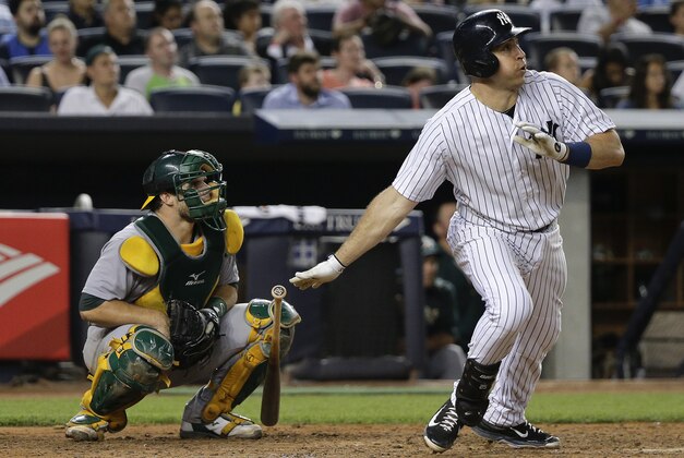 New York Yankees' Mark Teixeira, right, follows through on a solo home run as Oakland Athletics catcher Josh Phegley watches during the sixth inning of a baseball game, Wednesday, July 8, 2015, in New York. (AP Photo/Julie Jacobson)