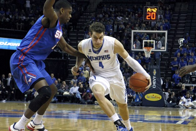 Memphis' Austin Nichols (4) powers past SMU's Yanick Moreira (2) in the first half of an NCAA college basketball game Thursday, Feb. 26, 2015, in Memphis, Tenn. (AP Photo/Karen Pulfer Focht)