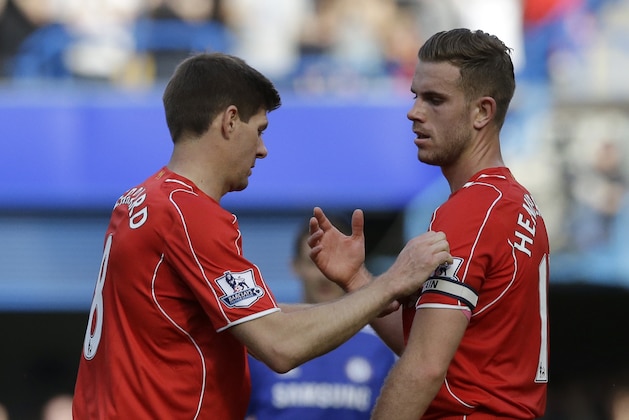Liverpool's Steven Gerrard, left, hands the captains arm band to teammate Jordan Henderson as he turns to go off the pitch as he is substituted during their English Premier League soccer match between Chelsea and Liverpool at Stamford Bridge stadium in London, Sunday, May 10,  2015. (AP Photo/Matt Dunham)
