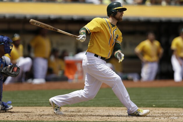 Oakland Athletics' Ben Zobrist swings for an RBI sacrifice fly against the Kansas City Royals in the third inning of a baseball game Sunday, June 28, 2015, in Oakland, Calif. (AP Photo/Ben Margot)
