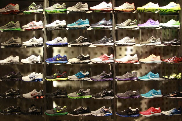 Nike running shoes are shown on display at Niketown in Portland, Ore., Monday, June 27, 2011. Nike Inc.'s fourth-quarter net profit rose 14 percent to beat expectations as the company's sales improved around the globe. (AP Photo/Rick Bowmer)