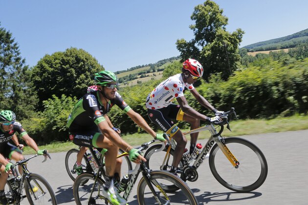 Eritrea's Daniel Teklehaimanot, wearing the best climber's dotted jersey, rides next to Brice Feillu of France, center, during the seventh stage of the Tour de France cycling race over 190.5 kilometers (118.4 miles) with start in Livarot and finish in Fougeres, France, Friday, July 10, 2015. (AP Photo/Christophe Ena)