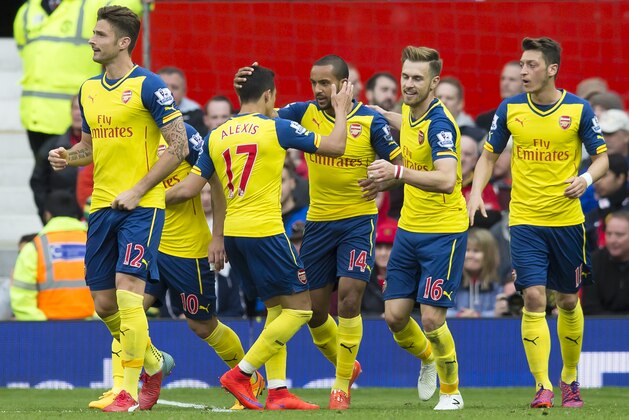 Arsenal's Theo Walcott, centre left, celebrates with teammates after scoring during the English Premier League soccer match between Manchester United and Arsenal at Old Trafford Stadium, Manchester, England, Sunday, May 17, 2015. (AP Photo/Jon Super)