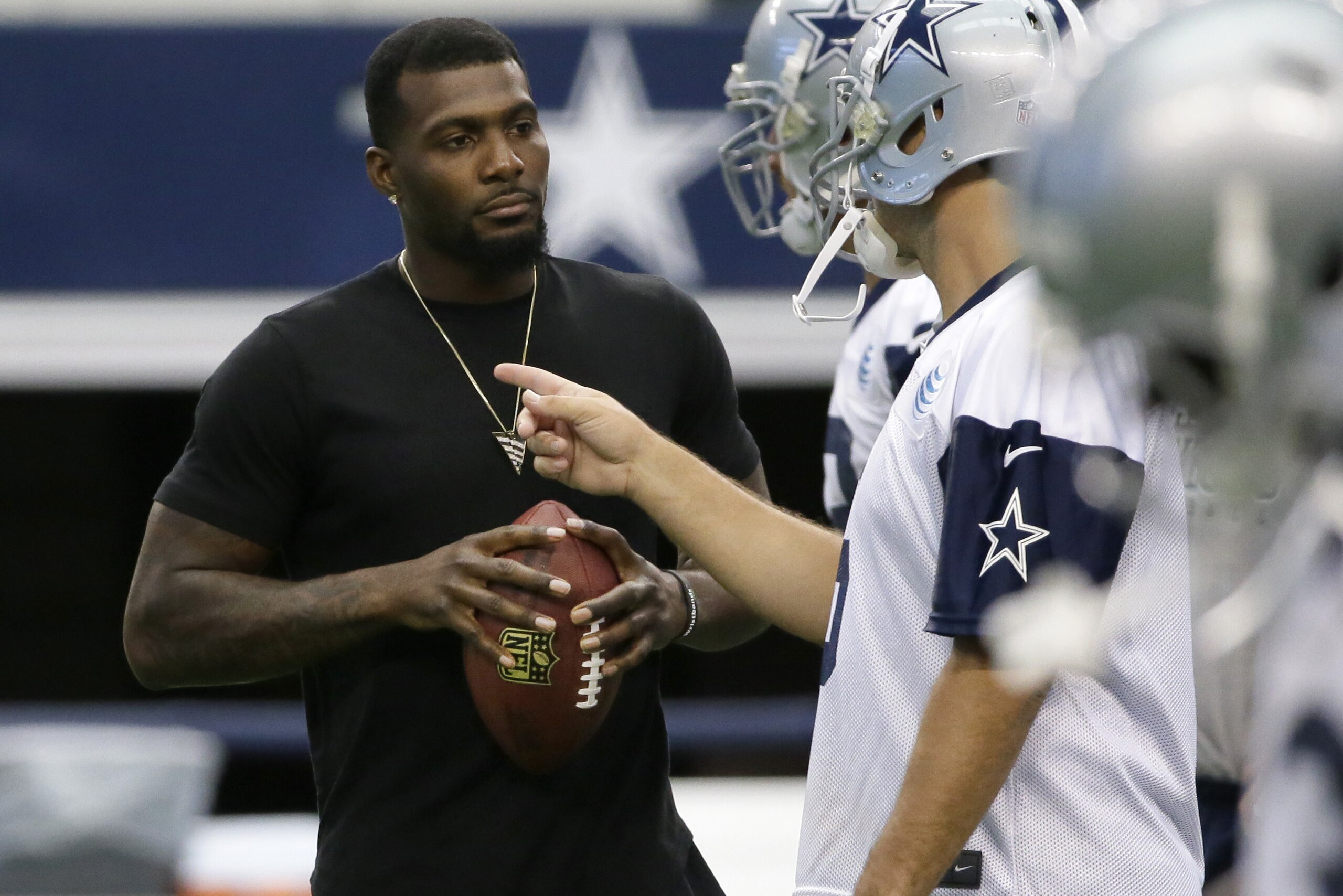 Dallas Cowboys wide receiver Dez Bryant, left, listenes to Tony Romo (9) during an NFL football minicamp at the team's stadium in Arlington, Texas, Thursday, June 18, 2015. (AP Photo/LM Otero)