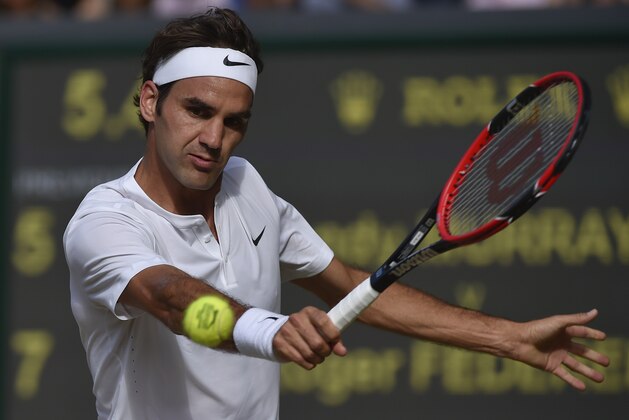 Roger Federer of Switzerland returns a shot to Andy Murray of Britain, during the men's singles semifinal match at the All England Lawn Tennis Championships in Wimbledon, London, Friday July 10, 2015. (Toby Melville/Pool Photo via AP)