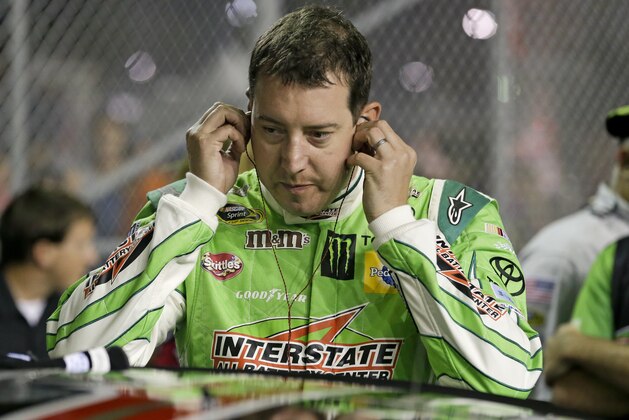 Kyle Busch puts on ear plugs before getting in his car for the start of a NASCAR Sprint Cup series auto race at Daytona International Speedway, Sunday, July 5, 2015, in Daytona Beach, Fla. (AP Photo/John Raoux)