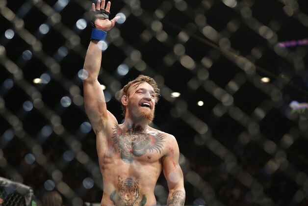 Conor McGregor celebrates between rounds against Chad Mendes during their interim featherweight title mixed martial arts bout at UFC 189 on Saturday, July 11, 2015, in Las Vegas. (AP Photo/John Locher)