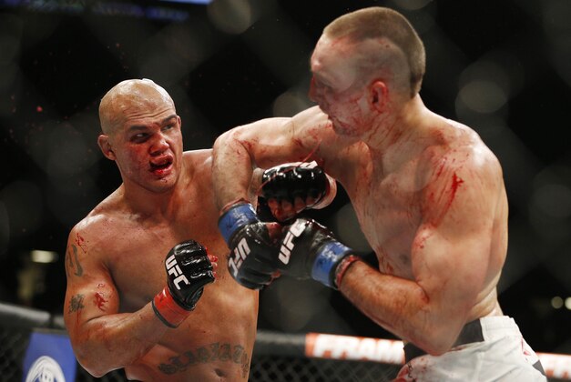 Robbie Lawler , left, lands a left hit to Rory MacDonald to end their welterweight title mixed martial arts bout at UFC 189 on Saturday, July 11, 2015, in Las Vegas. (AP Photo/John Locher)