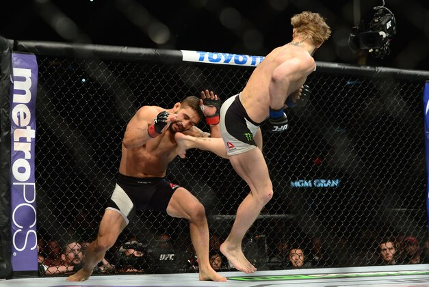 Jul 11, 2015; Las Vegas, NV, USA; Chad Mendes (red gloves) and Conor McGregor (blue gloves) fight during their interim featherweight title bout during UFC 189 at MGM Grand Garden Arena. McGregor won via second round TKO. Mandatory Credit: Joe Camporeale-USA TODAY Sports