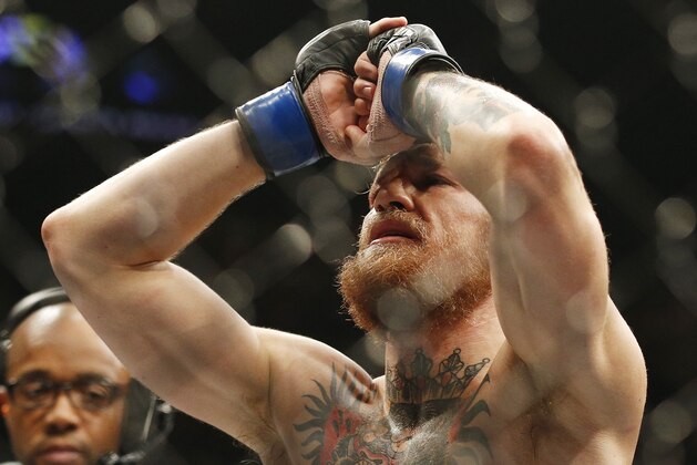 Conor McGregor celebrates after defeating Chad Mendes in their interim featherweight title mixed martial arts bout at UFC 189 Saturday, July 11, 2015, in Las Vegas. (AP Photo/John Locher)