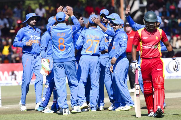 Indian cricket players  celebrate after dismissing Zimbabwean batsman Chamunorwa Chibhabha, right, or 3 runs during the One Day International against Zimbabwe in Harare, Zimbabwe, Friday, July,10, 2015.   (AP Photo/Tsvangirayi Mukwazhi)