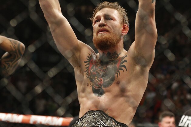Conor McGregor celebrates after defeating Chad Mendes in their interim featherweight title mixed martial arts bout at UFC 189 Saturday, July 11, 2015, in Las Vegas. (AP Photo/John Locher)