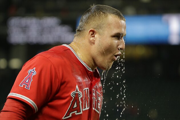 Los Angeles Angels' Mike Trout recovers after teammate Albert Pujols poured ice water on him during a post-game interview after Trout hit two home runs to lead the Angels to a 7-3 win over the Seattle Mariners in a baseball game, Friday, July 10, 2015, in Seattle. (AP Photo/Ted S. Warren)