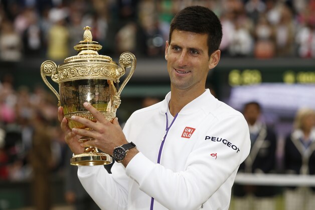 Novak Djokovic of Serbia holds the trophy after winning the men's singles final against Roger Federer of Switzerland at the All England Lawn Tennis Championships in Wimbledon, London, Sunday July 12, 2015. Djokovic won the match 7-6, 6-7, 6-4, 6-3.