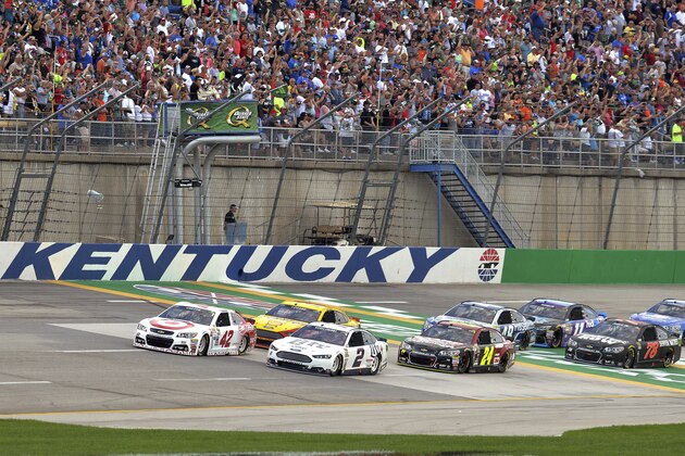 Kyle Larson (42), and Brad Keselowsi (2) lead the pack at the start of the NASCAR Sprint Cup auto race at Kentucky Speedway in Sparta, Ky., Saturday, July 11, 2015. (AP Photo/Timothy D. Easley)