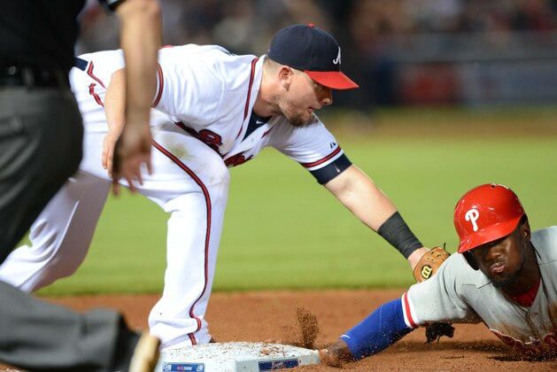 Philadelphia Phillies center fielder Odubel Herrera is safe diving back to first base on a pick-off attempt as Atlanta Braves first baseman Chris Johnson applies the tag during the seventh inning of a baseball game Friday, July 3, 2015, in Atlanta. (AP Photo/Jon Barash)