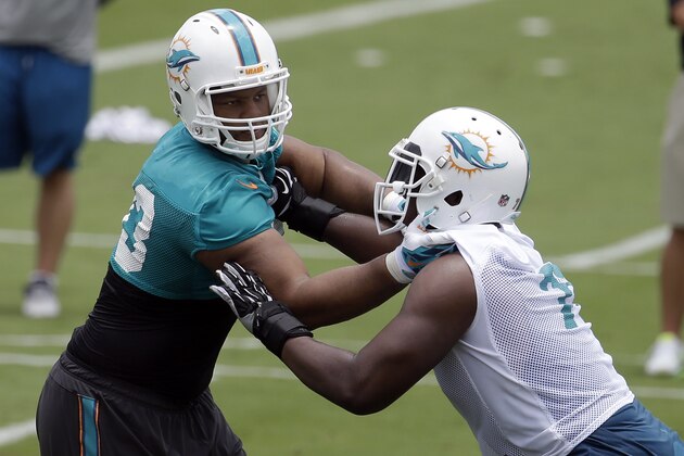 Miami Dolphins defensive tackle Ndamukong Suh, left, works on a drill with Ja'Wuan James (70) during an NFL football organized team activity, Monday, June 8, 2015, in Davie, Fla. (AP Photo/Lynne Sladky)