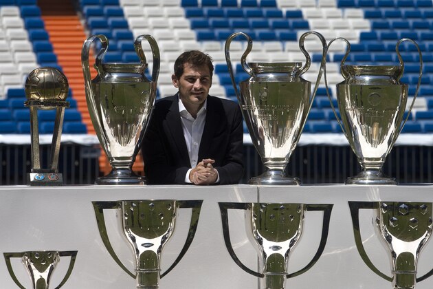 Goalkeeper Iker Casillas poses by some of the trophies he won as a player with Real Madrid after a press conference at the Santiago Bernabeu stadium in Madrid, Spain, Monday July 13, 2015. Casillas appeared with the club’s president a day after he gave an emotional press conference alone putting an end to his 25 years as a Real Madrid goalkeeper. Casillas will now play for FC. Porto. (AP Photo/Paul White)