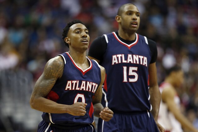 Atlanta Hawks guard Jeff Teague (0) and enter Al Horford (15), from the Dominican Republic, jog to the bench during a break in the first half of Game 4 of the second round of the NBA basketball playoffs against the Washington Wizards, Monday, May 11, 2015, in Washington. The Hawks won 106-101. (AP Photo/Alex Brandon)
