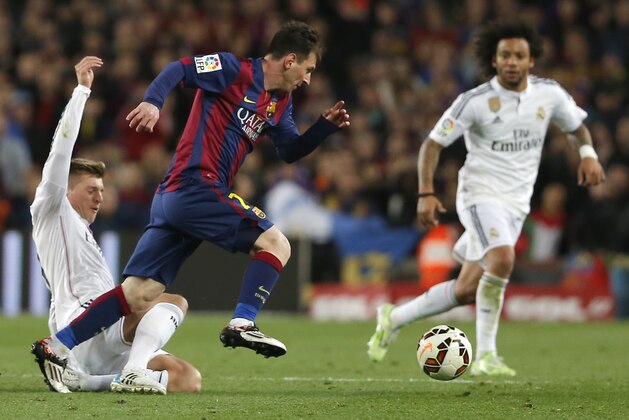 Real Madrid's Toni Kroos, left, and Real Madrid's Marcelo, right, vie for the ball with Barcelona's Lionel Messi during a Spanish La Liga soccer match between FC Barcelona and Real Madrid at Camp Nou stadium, in Barcelona, Spain, Sunday, March 22, 2015. Barcelona won the match with a 2-1 score. (AP Photo/Emilio Morenatti)