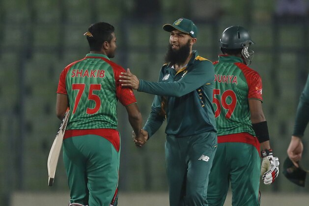 Bangladesh’s Shakib Al Hasan, left, shakes hand with South Africa’s captain Hashim Amla, center, after winning their second one-day international cricket match in Dhaka, Bangladesh, Sunday, July 12, 2015. Bangladesh won by 7 wickets. (AP Photo/ A.M. Ahad)