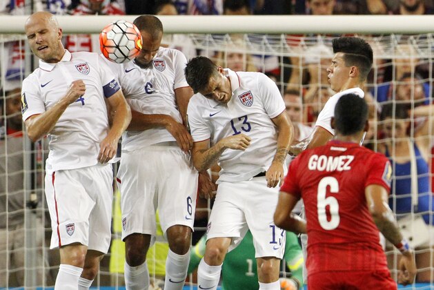 USA's Michael Bradley (4) John Brooks (6) and Ventura Alvarado (13) block a penalty kick by Panama midfielder Gabriel Gomez during the first half of a CONCACAF Gold Cup soccer match, Monday, July. 13, 2015, in Kansas City, Kan. (AP Photo/Colin E. Braley)