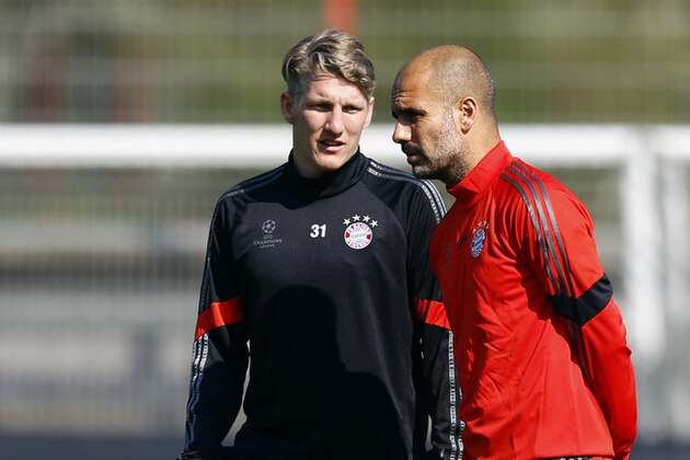 Bayern's Bastian Schweinsteiger, left, talks to head coach Pep Guardiola from Spain during a training session prior to the Champions League quarterfinal second leg soccer match between FC Bayern Munich and FC Porto at Allianz Arena in Munich, southern Germany, Monday, April 20, 2015.  (AP Photo/Matthias Schrader)