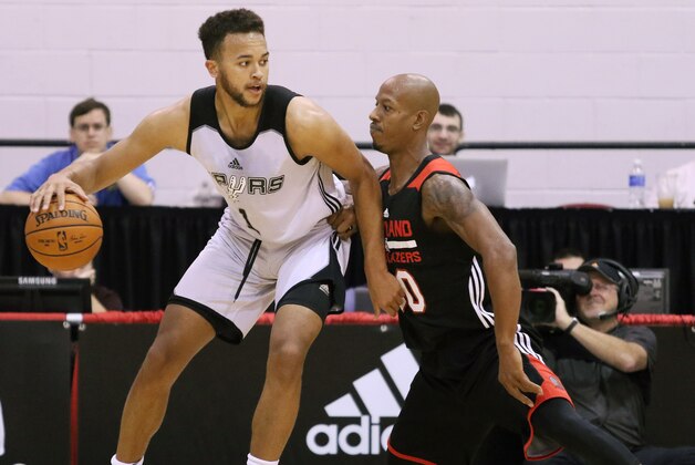 San Antonio Spurs' Kyle Anderson, left, is defended by Portland Trail Blazers' Keith Bogans during the first half of an NBA summer league basketball game Tuesday, July 14, 2015,  in Las Vegas. (AP Photo/Ronda Churchill)